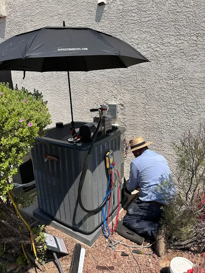 HVAC technician performing outdoor AC maintenance in Vero Beach