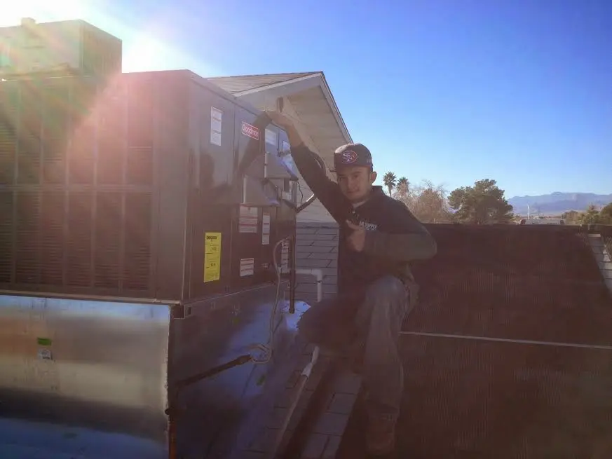 HVAC technician performing AC Tune-Up on a rooftop unit in Vero Beach
